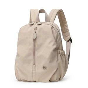 Detail view of beige nylon travel backpack showing side pockets and vertical front zipper