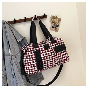 Macro detail of red and white houndstooth fabric with embossed logo and black zippers
