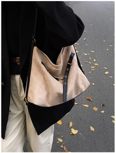 Detail of khaki frosted leather tote bag with black straps and vintage bronze buckle