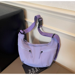 Detail of purple nylon crescent bag showing dual front zippers and wide adjustable strap