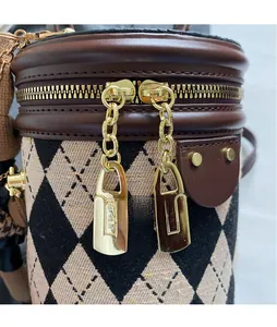 Detail of retro argyle bucket bag showing gold double zippers and long chain pullers