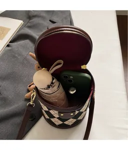 Detail showing spacious interior of checkered bucket bag with phone and umbrella storage