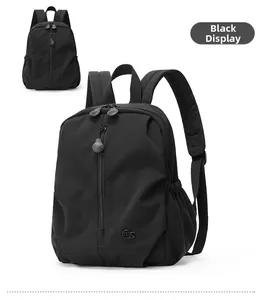 Detailed view of black nylon backpack featuring vertical zipper and elastic side pockets