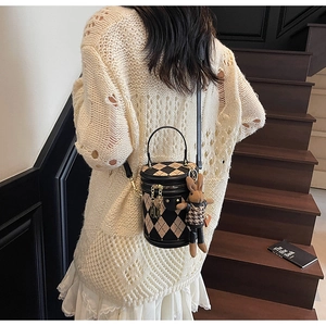 Detail view of retro cylindrical bucket bag with diamond lattice and cute bunny charm