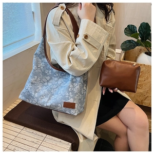 Detail of floral tote bag set with brown leather strap and matching pouch on a model