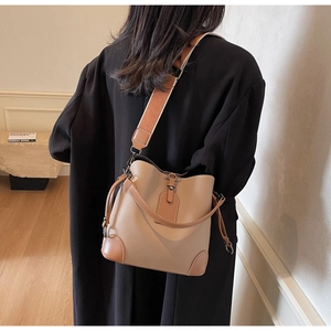 Detail view of khaki leather bucket bag featuring a textured finish and stylish shoulder strap