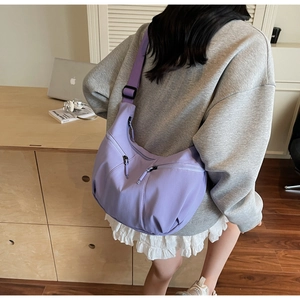 Detail of light purple nylon dumpling bag showing matte texture and double curved zippers