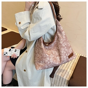 Chic clover pattern tote bag shown over the shoulder with a beige autumn trench coat