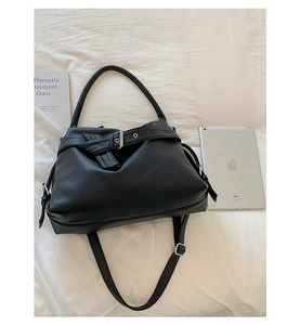 Close-up of black pebbled leather tote with silver buckle and adjustable shoulder strap