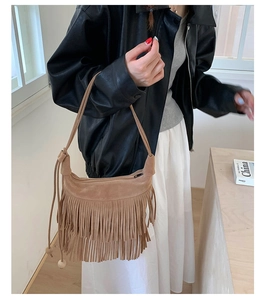 Borsa a spalla in pelle scamosciata marrone con frange bohémien indossata da una modella