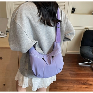 Detailed view of the light purple nylon crescent bag with decorative metal zippers