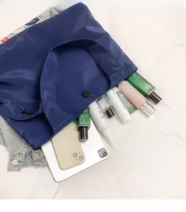 Top view of blue nylon tote bag showing spacious interior with tablet and cosmetics