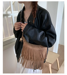 Dettaglio borsa bohémien marrone con frange in pelle scamosciata e perline di legno