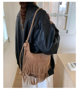Dettaglio della borsa a tracolla bohemian in pelle scamosciata con lunghe frange