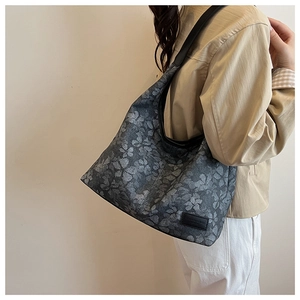 Model showing a large grey floral tote bag with black straps for daily commute