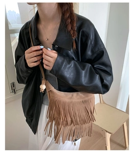 Dettaglio borsa a tracolla bohémien in pelle scamosciata marrone con frange e perla di legno