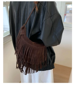 Modella che indossa borsa a tracolla a mezzaluna marrone con lunghe frange stile bohémien