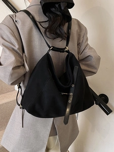 Minimalist black matte tote backpack with industrial metal eyelets and adjustable strap