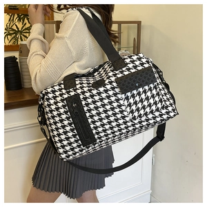 Side view of houndstooth travel bag with large front flap pocket and adjustable shoulder strap