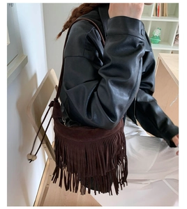 Dettaglio della borsa a spalla in pelle scamosciata marrone scuro con lunghe frange boho
