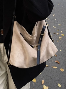 Beige matte suede hobo bag with black leather shoulder strap and gold hardware accents