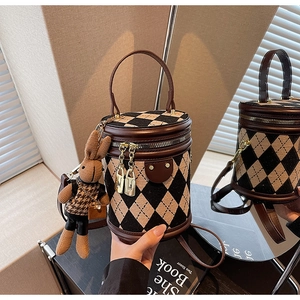 Close-up of diamond pattern bucket bag with golden double zippers and rabbit charm