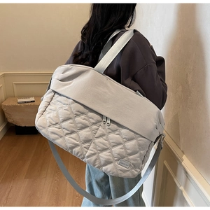 Detailed back view of a light gray quilted nylon travel tote bag with wide straps