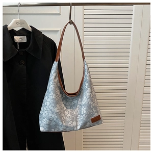 Detail of floral canvas hobo bag with brown leather straps and spacious interior
