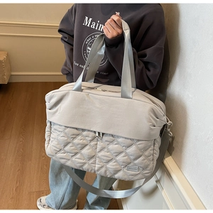 Close-up of light gray travel bag showing quilted rhombic pattern and NINGJIA logo
