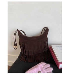 Dettaglio borsa in pelle scamosciata marrone con frange lunghe e perline in legno