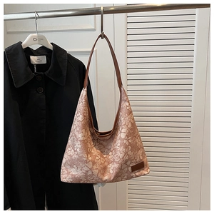 Detail of floral hobo bag featuring vintage pattern and premium brown leather strap
