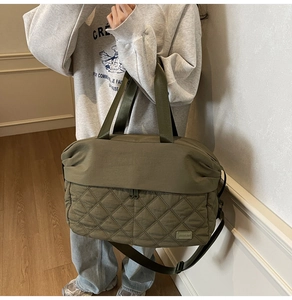 Detail of olive green quilted tote bag showing adjustable strap and large capacity