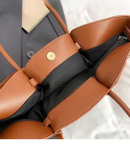 Close-up of brown suede tote bag interior with magnetic snap closure and black lining