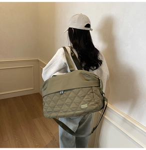Detailed macro view of an olive green quilted travel bag with premium diamond stitching texture