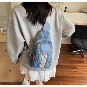 Detail of floral embroidery on a vintage wash denim crossbody chest bag for women