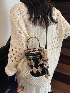 Chic quilted cylinder bucket bag in black and cream featuring a cute rabbit charm accessory