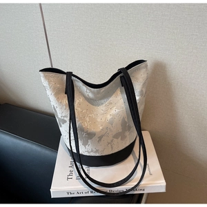 Detail view of the butterfly print on this high-capacity canvas bucket shoulder bag