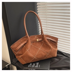 Close-up of dark brown suede tote bag with white diamond stitching and gold metal buckle