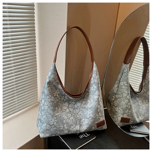 Detail view of the floral jacquard fabric and premium brown leather handle on the tote bag