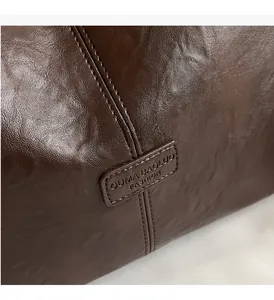 Close-up of vintage dark brown faux leather tote showing fine stitching and embossed logo