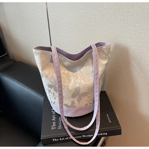 Detail view of purple and beige canvas tote bag with butterfly print and silver rivets