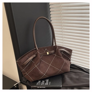 Close-up of retro brown faux suede tote bag with white diamond stitching and metal buckle