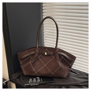 Detail view of brown suede tote bag featuring white diamond stitching and metal buckle