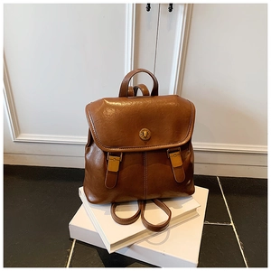 Detail view of the vintage dark brown leather backpack with polished metallic buckle