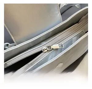 Detail shot of the metallic silver crossbody bag with premium metal zipper and magnetic buckle