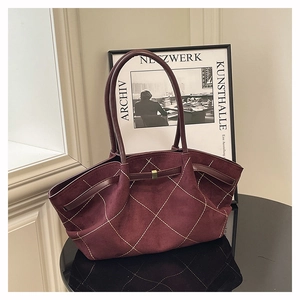 Detail of burgundy suede tote bag featuring white diamond quilting and metallic buckle