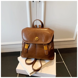 Detailed close-up of brown vintage backpack with gold twist lock and leather straps
