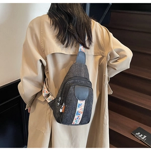 Crossbody chest bag with ethnic floral strap worn by model on wooden stairs
