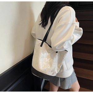 Detail of canvas tote bag featuring butterfly print and black contrast shoulder straps