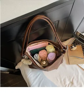 Internal view of a spacious brown tote bag holding a tablet, bottle, and umbrella